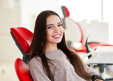 Teen girl smiling while sitting in treatment chair