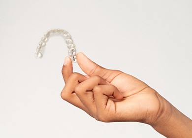 Closeup of teen holding clear aligner