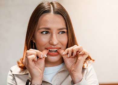 Patient putting on clear aligner in treatment room