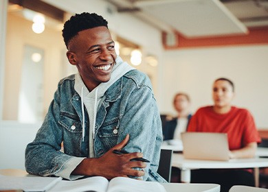 Teen in denim jacket smiling in classroom
