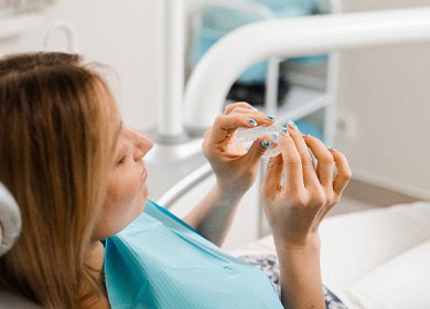 Patient holding clear aligner in treatment room