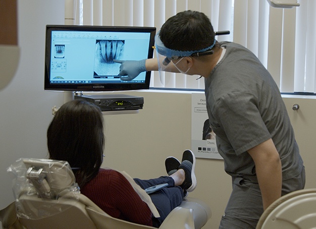Dentist and team member looking at digital images