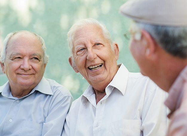 Three men with dentures smiling