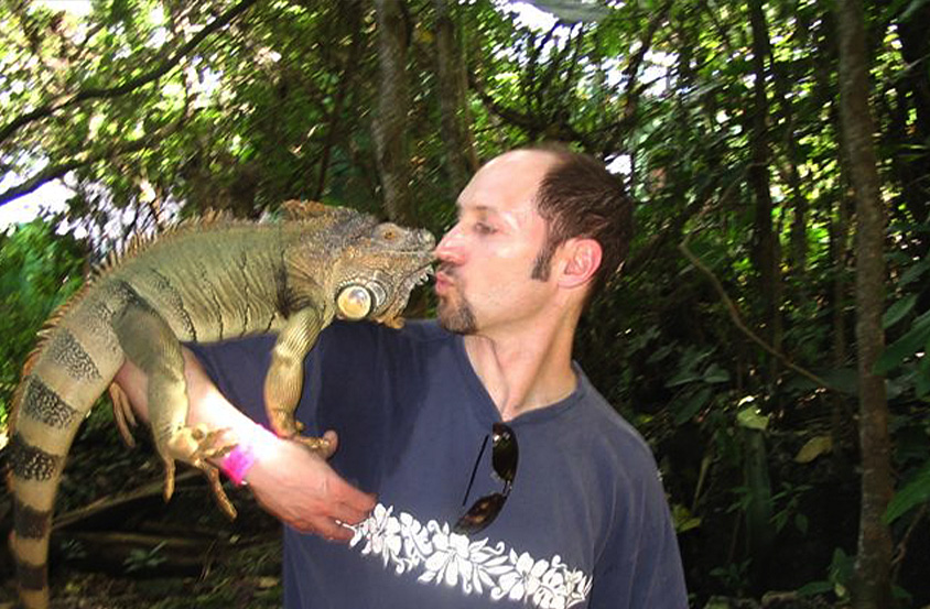 Doctor Rauchberg holding an iguana in Jamaica for vacation