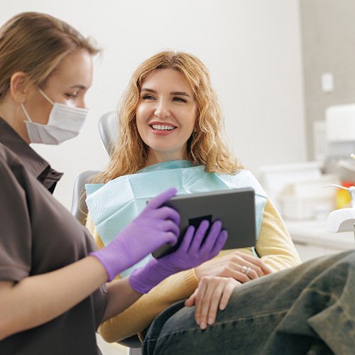 Patient and dental team member looking at tablet together