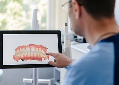 Dentist pointing at image produced by digital impression scan