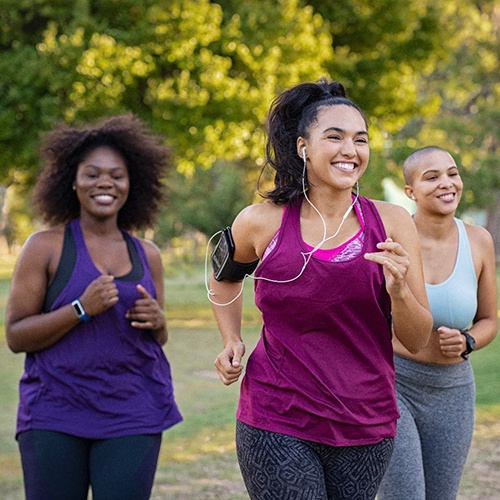 Group of women smiling while jogging in park