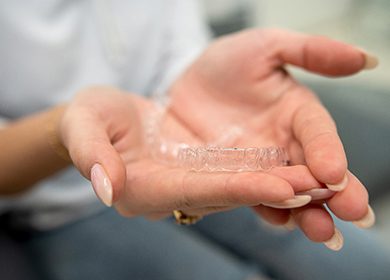 Closeup of patient holding clear aligner
