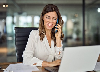 Woman smiling while talking on phone in office