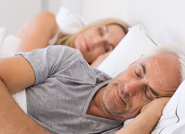 Man and woman sleeping soundly thanks to sleep apnea therapy