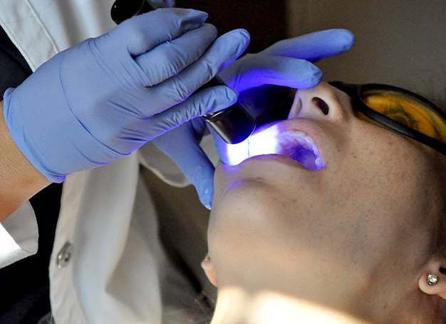 Patient receiving oral I D oral cancer screening