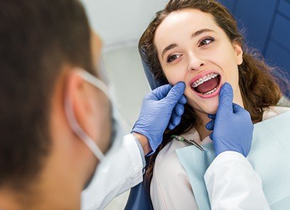 Orthodontist examining patient's braces