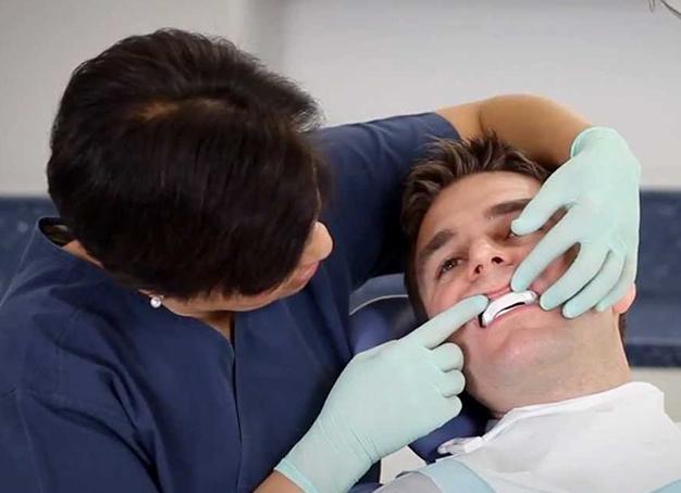 Dentist fitting sleep apnea patient for CPAP alternative oral appliance