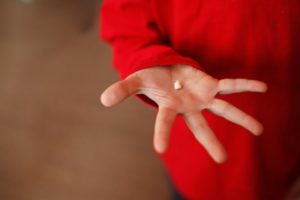 A child holding their baby tooth.