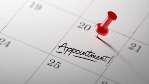 Calendar with a red push pin and the word "appointment" on a date 