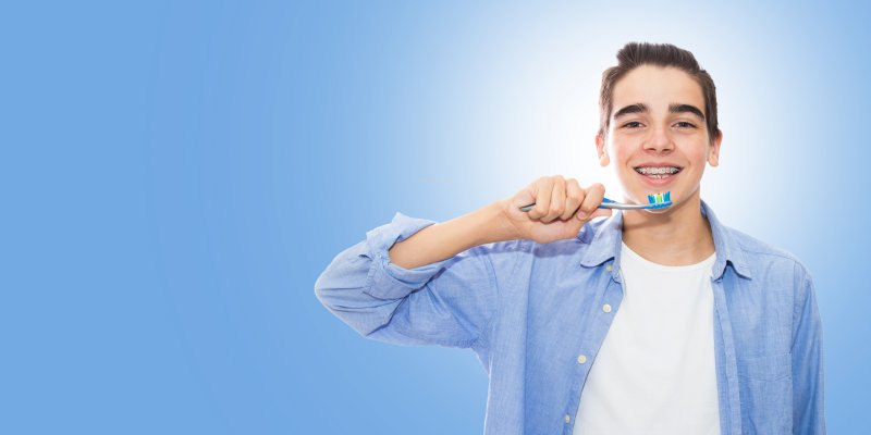 boy cleaning teeth with metal braces in Parsippany