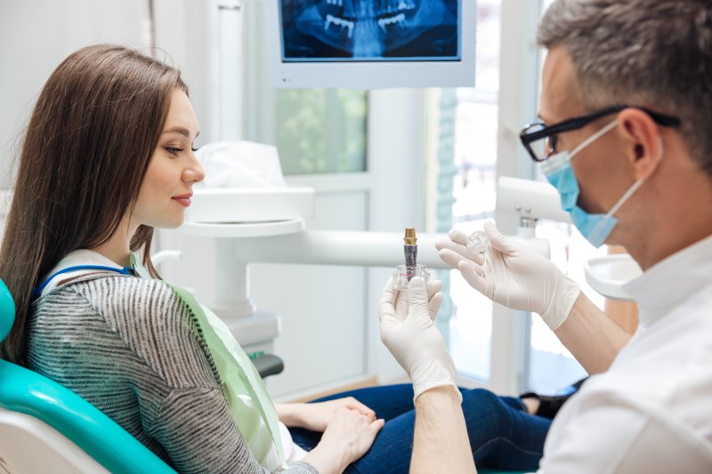 A dentist explaining when a patient can get dental implants after tooth extraction in Parsippany