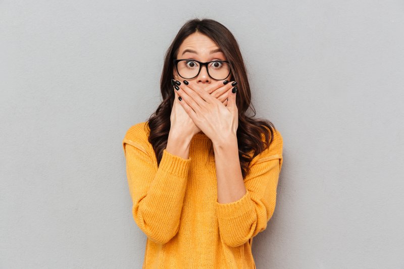 woman covering her gray teeth in Parsippany