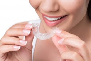 woman inserting clear aligners