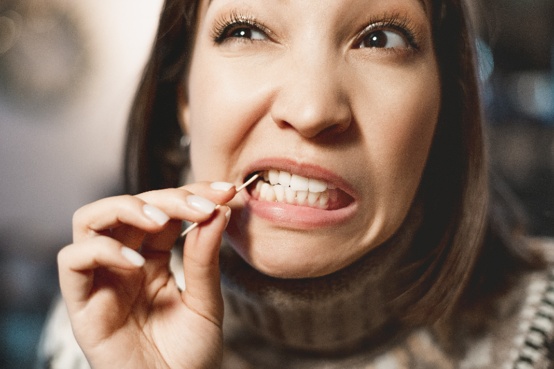Patient with good oral health using a toothpick