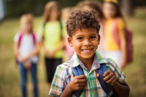 little boy with backpack and smiling